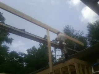 Carpenter setting a ridge beam over a new addition frame — Ice Dam Removal by Roofing Brothers in Clear Lake